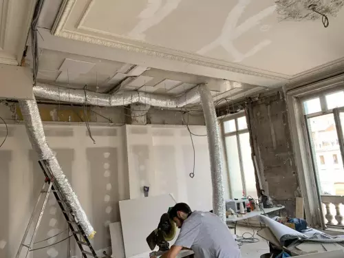 Cette image représente un chantier en cours de réalisation pour la réfection d'un plafond traditionnel en lattis plâtre avec des corniches ornementées et moulures staff à Lyon